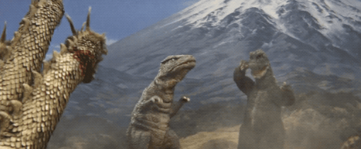 Godzilla and Gorosaurus charge an injured King Ghidorah with Mount Fuji as a backdrop