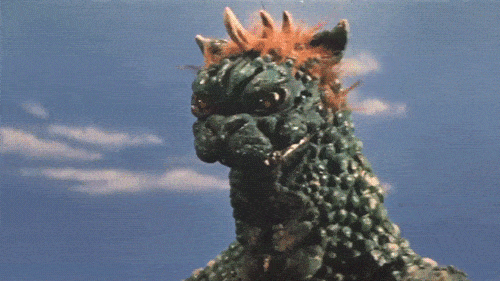 Gabara bullying Minilla, horns glow, and lightning courses through his hand before a punch