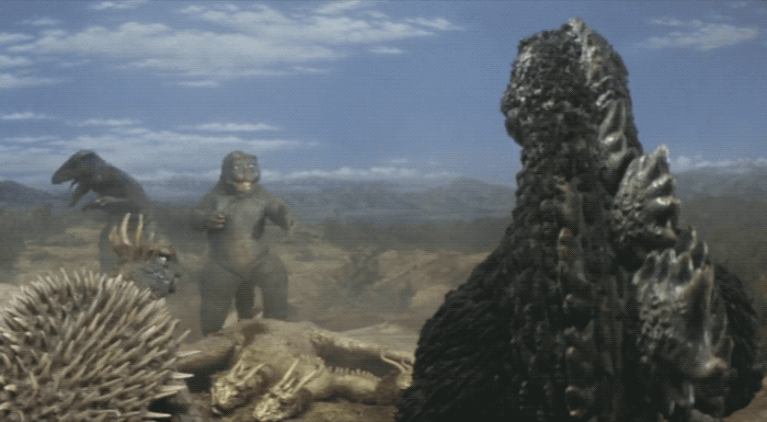 Minilla striking a hilarious victory pose over King Ghidorah's body while Godzilla, Gorosaurus, and Anguirus look on