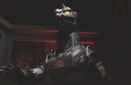 Mechagodzilla raises his right hand across his chest in the first half of a nazi salute