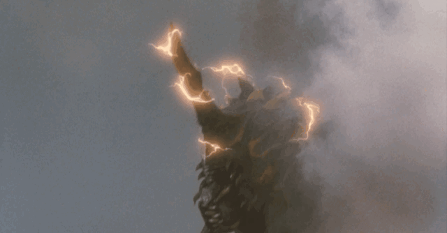 Battra fires orange lasers from his horn, and purple lasers from his eyes destroying some tanks nearby