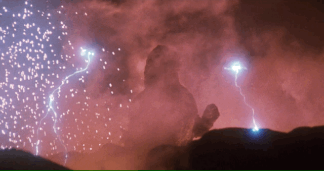 Godzilla rises from a volcano while lightning crackles around him