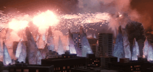 SpaceGodzilla fires crystals through the air like rockets, sparks fly as they are launched and explode