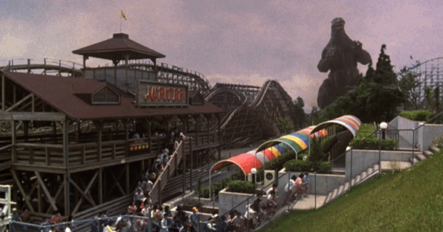 Amusement park goers evacuate as Godzilla approaches, an unfortunate group is still trapped on the ride as a coaster gets set into motion