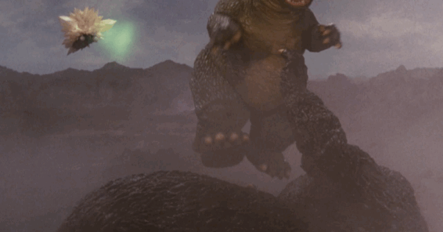 SpaceGodzilla using a green beam to levitate Little Godzilla and imprison him in crystals