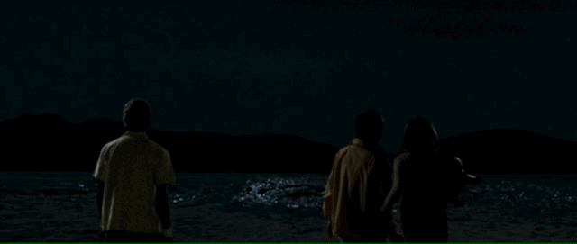 A giant larva rises from an ocean to menace teens on a beach, one teen trips, looking back to face his fate