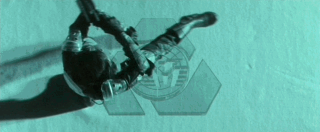 Twenty people with guns performing flips and martial arts moves in synchronization